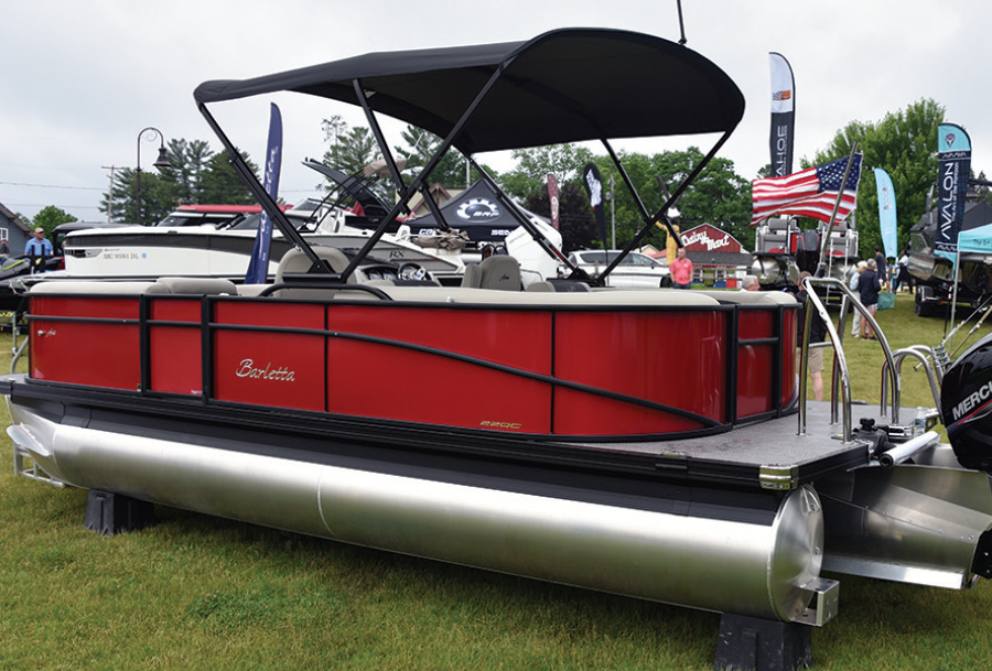 red pontoon parked on grass with black head cover