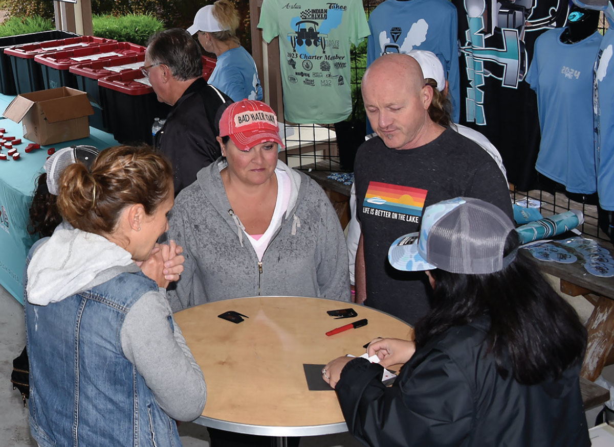 table of two women and one man in front of card dealer during event