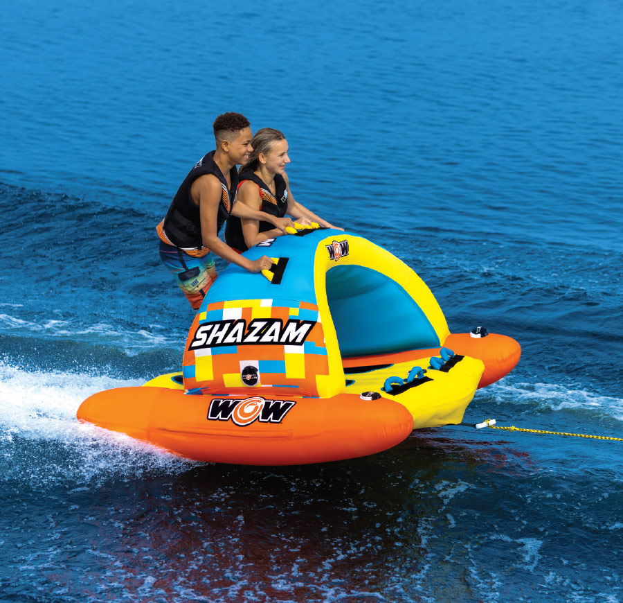 girl and guy riding orange, yellow, and blue WOW Shazam Towable