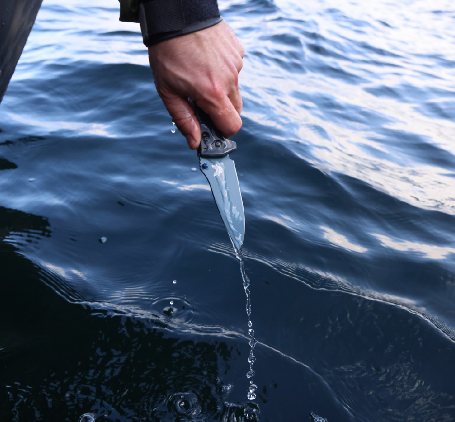 Benchmade Knife being pulled out of the water by someone's hand