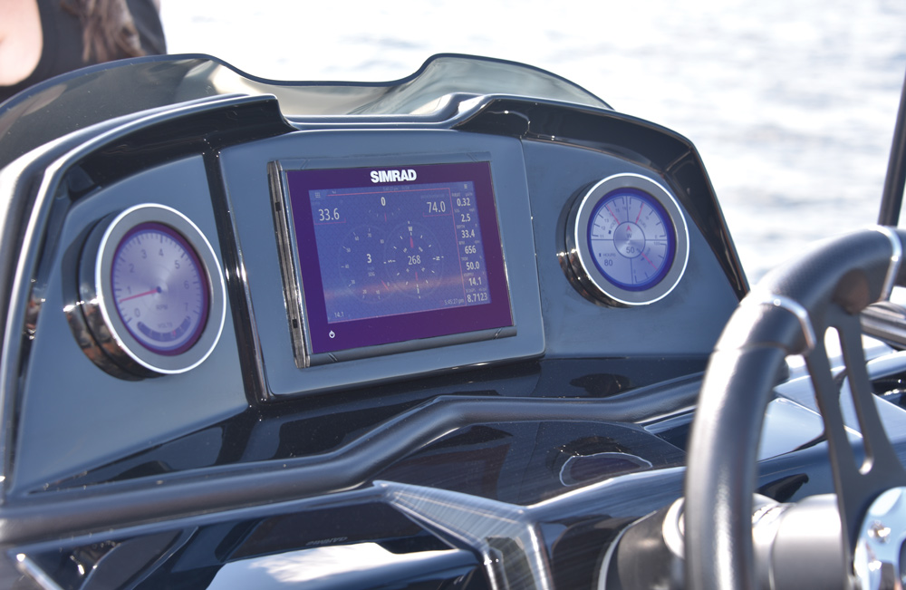 Boat dashboard with a SIMRAD digital display and two analog gauges.