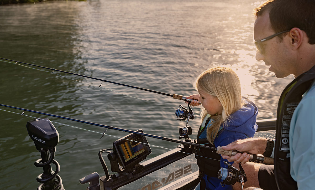 dad and daughter fishing off the side of a Sea-Doo pontoon