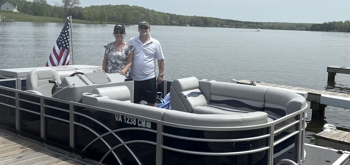 Robert Rounds and his wife standing in their boat