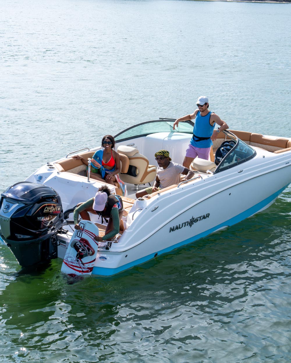 two men and two women in NauticStar 243DC pontoon getting gear set up to wakeboard