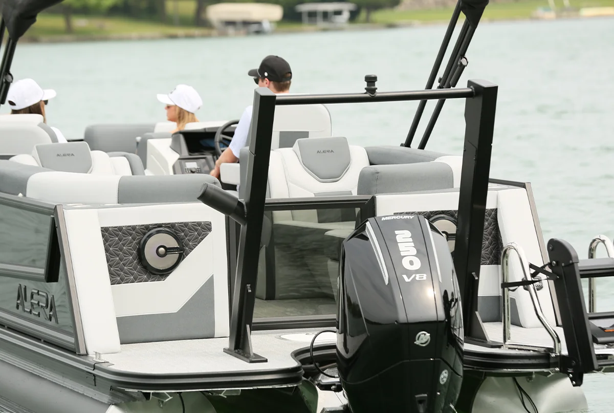 Rear view of a modern pontoon boat with a Mercury 350 V8 outboard motor, carrying passengers on the water.
