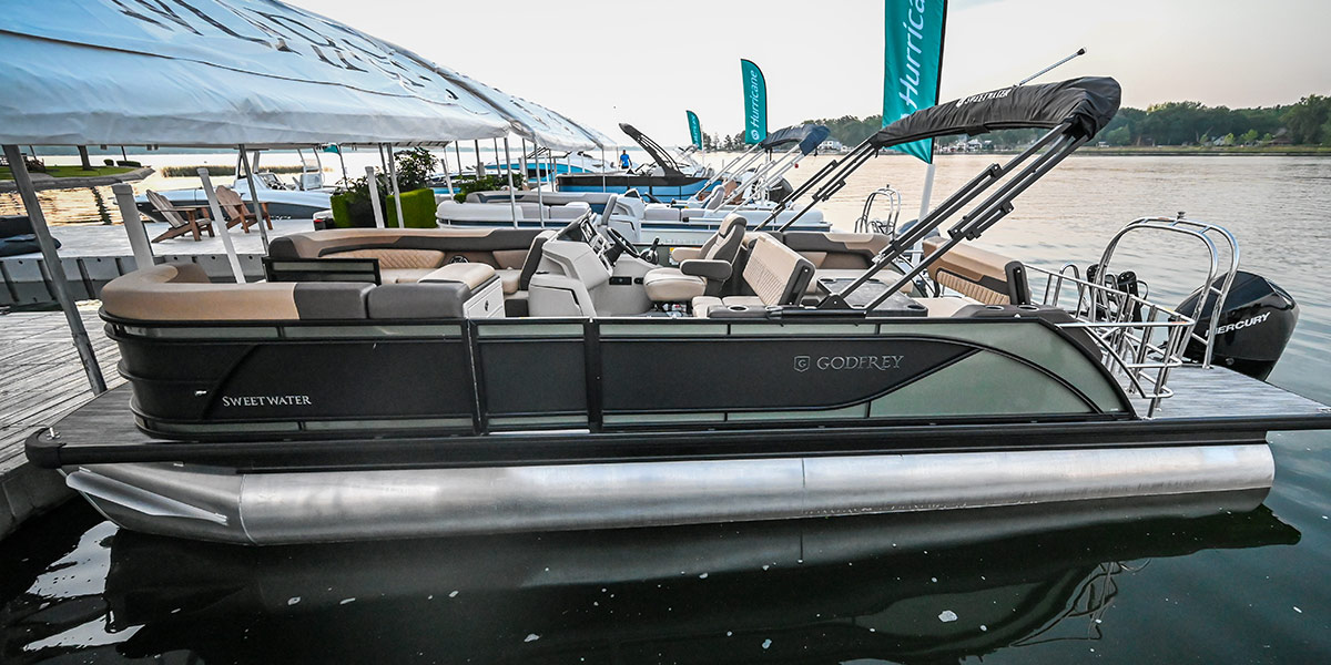 direct port side view of a line of different colored Godfrey Marine pontoons parked at a pier