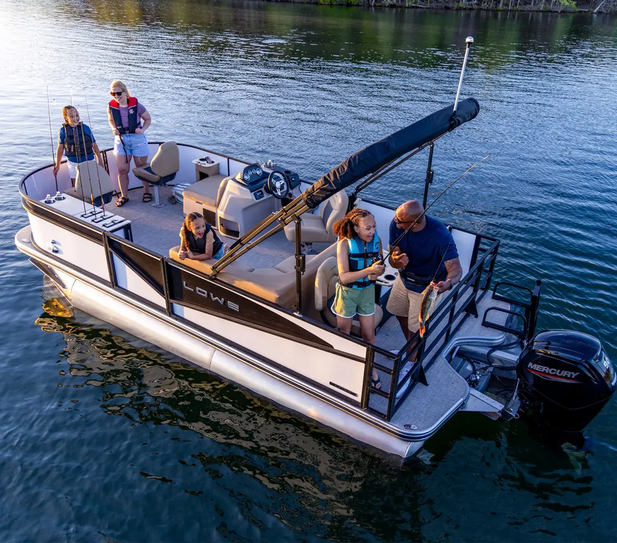 a family enjoys fishing together while on a Lowe Boat pontoon on a body of water