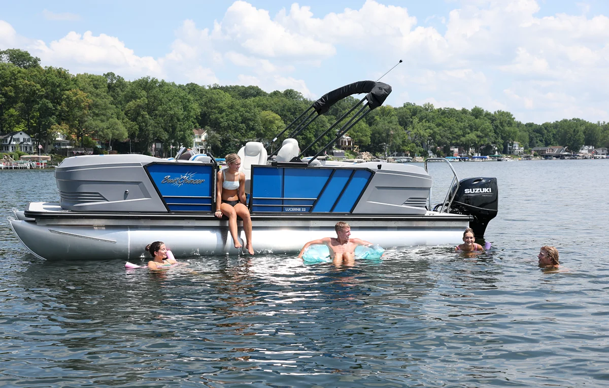 a group of five people enjoy a swim and a day on the water in a gray and blue accented SunCatcher pontoon
