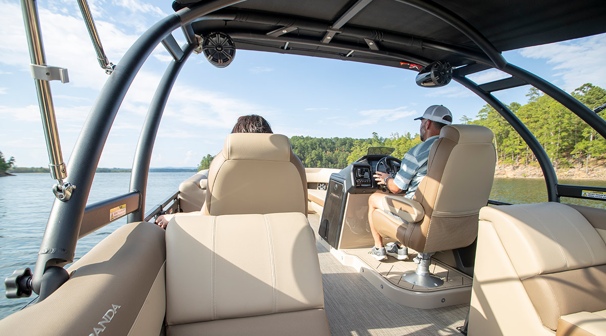 view from a passenger bench of the occupied helm and main passenger seat on Veranda Luxury pontoon in sail