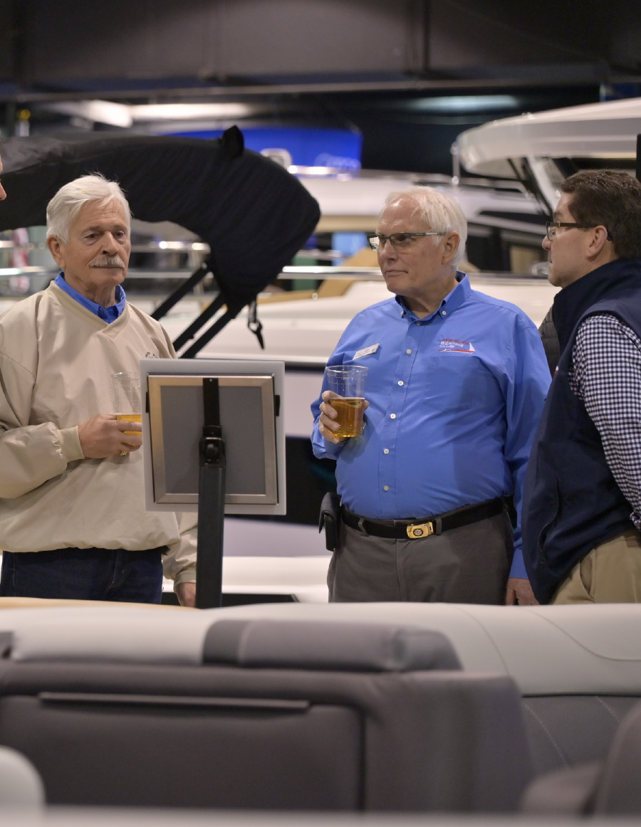 men at boat show holding drinks