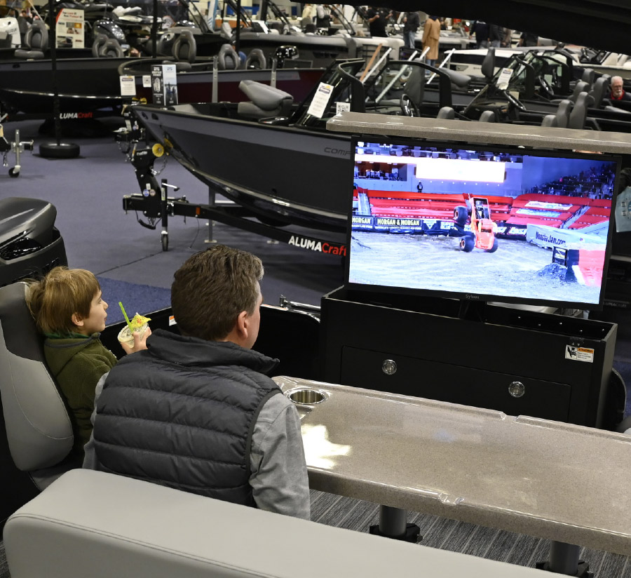 man and his son looking at tv displaying pontoon footage