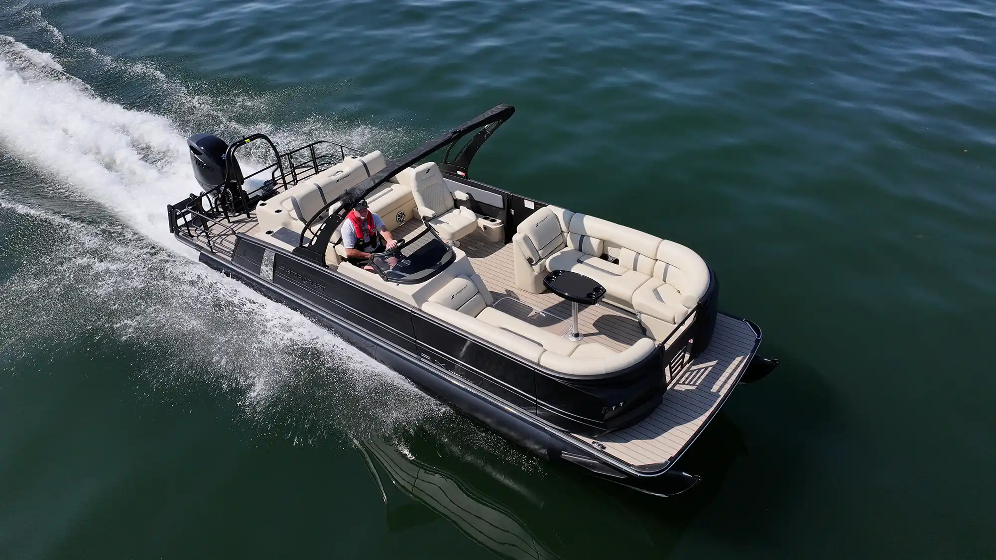 High-performance Starcraft triple-tube pontoon powered by a black outboard motor, showcasing its smooth handling and speed on open water.