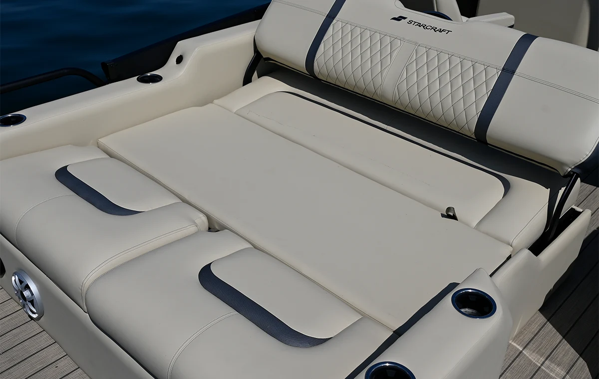 Close-up of the versatile rear lounging area on a luxury Starcraft boat, featuring premium tan upholstery and integrated cup holders.