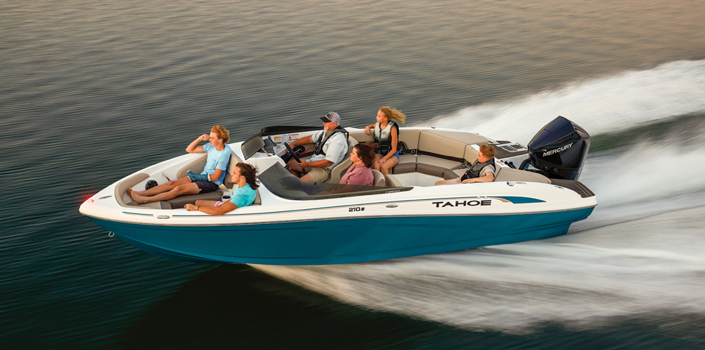 A teal and white Tahoe 210 S sport boat cruises with five passengers on board. The sleek hull is paired with a large black Mercury outboard engine.