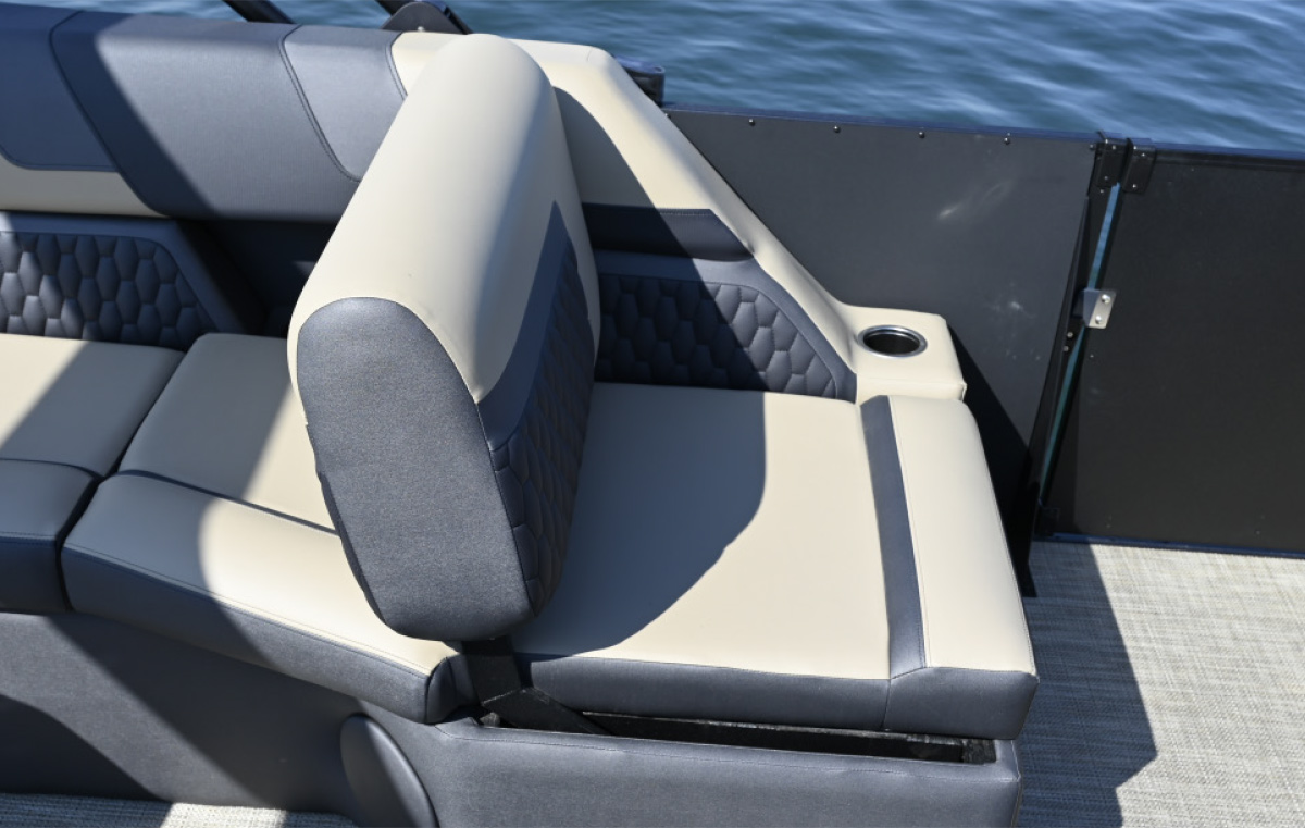 Close-up of a tan and charcoal grey boat seat featuring a quilted diamond pattern on the backrest and a built-in cup holder.
