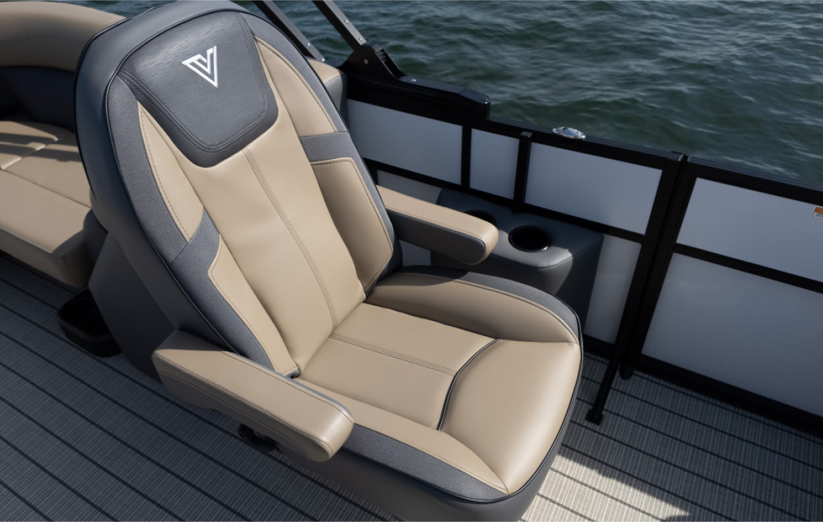 Detailed shot of a Viaggio swivel captain's chair in tan and charcoal grey with flip-up armrests on a plank-style boat deck.