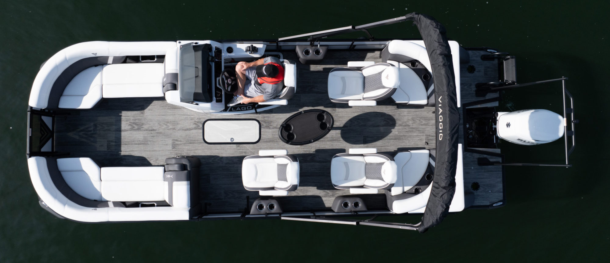 Bird's-eye view of a white and black Viaggio boat on dark water, showing a layout with four white swivel chairs and a central black table.
