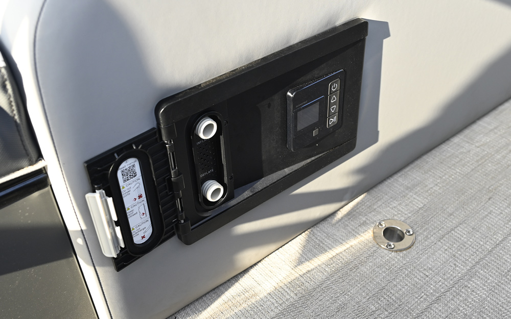 Close-up of a built-in utility panel on the side of a seat containing air pump ports labeled "Inflate" and "Deflate," alongside a digital control interface with a small screen.