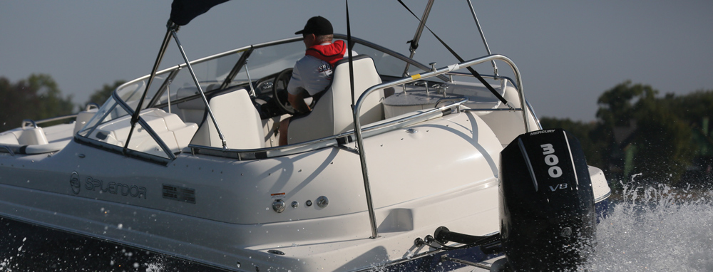 Rear view of a white Splendor deck boat cruising on open water, powered by a black Mercury 300 V8 outboard motor with a driver at the helm.