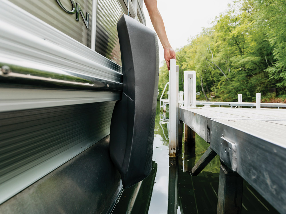 Boat fender between a dock and a metal boat.