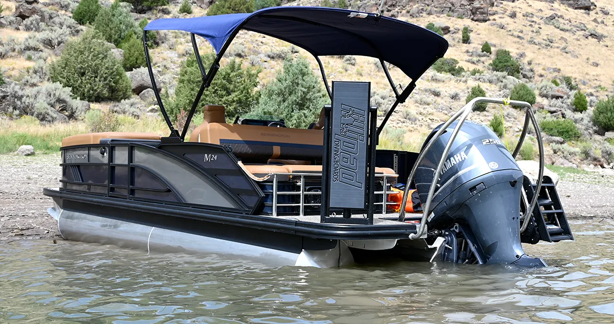 The rear view of a Bennington M24 pontoon boat with a blue bimini top and a Yamaha 250 engine