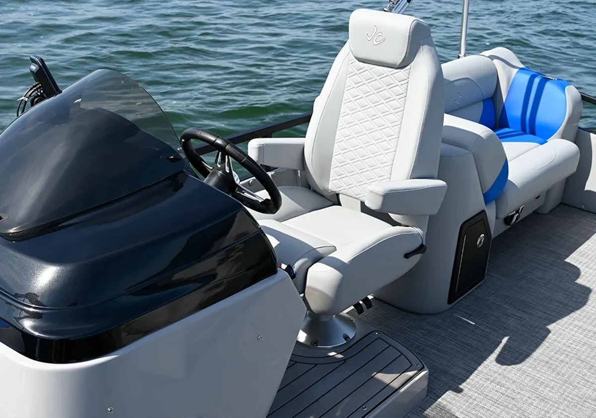 A spacious and modern living room suite at Oakwood Resort, featuring a charcoal grey sofa, hardwood floors, and large windows with white blinds overlooking Lake Wawasee
