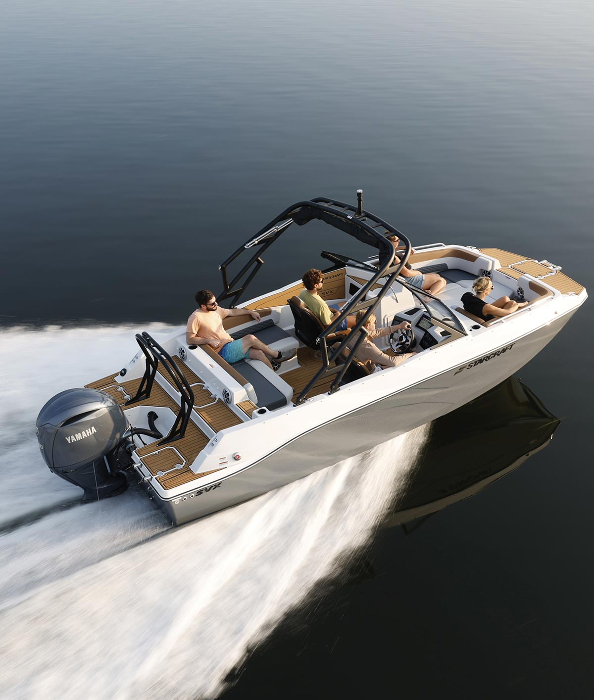 High-angle view of five people cruising on a Starcraft SVX motorboat with a Yamaha outboard motor. The boat speeds across calm water, leaving a large white wake.