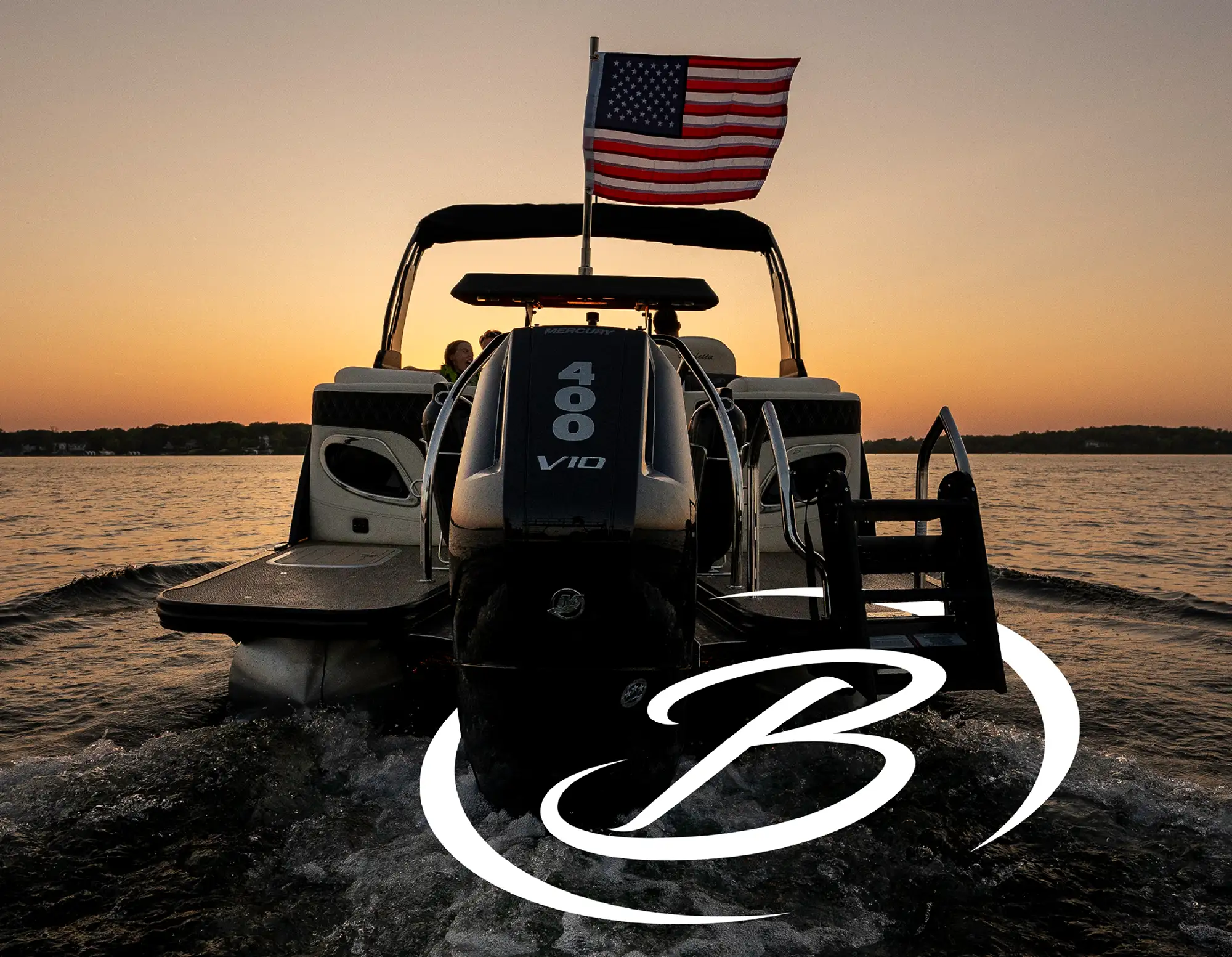 A black motorboat with an American flag rides over water at sunset, featuring a prominent engine that reads "400 V10."