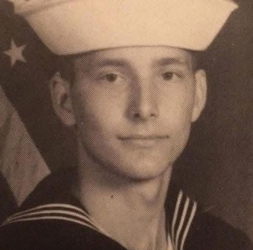 Vintage military portrait of a young man wearing a U.S. Navy uniform.