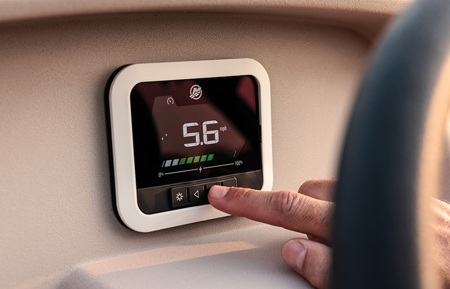 Close-up of a finger pressing a button on a boat’s digital speed display showing 5.6 mph.