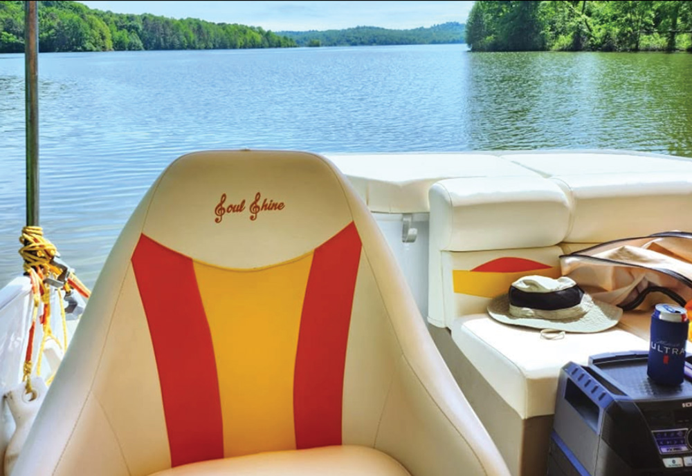 High-back vinyl boat seat embroidered with "Soul Shine" facing a serene lake landscape.