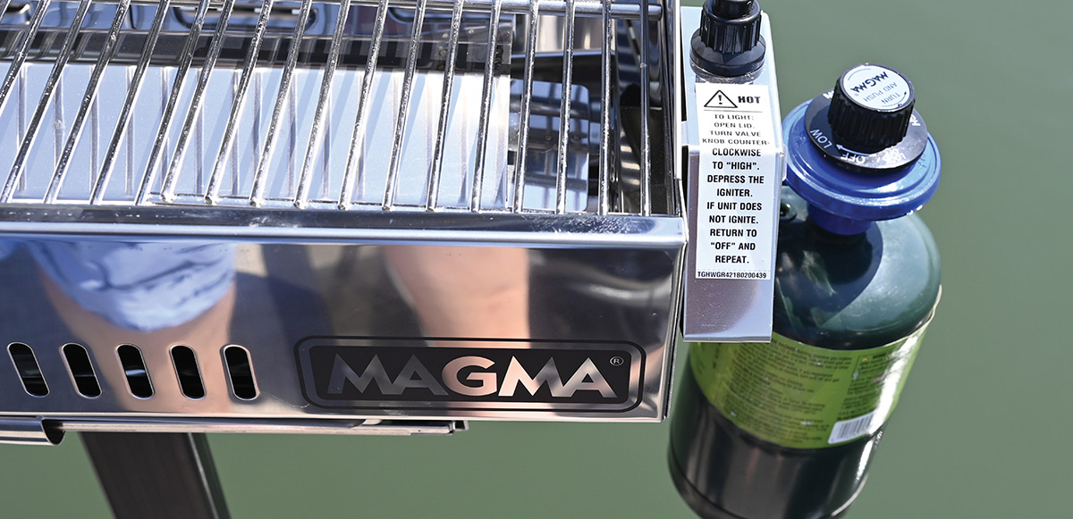 Close-up of a Magma stainless steel boat grill control valve and propane canister.