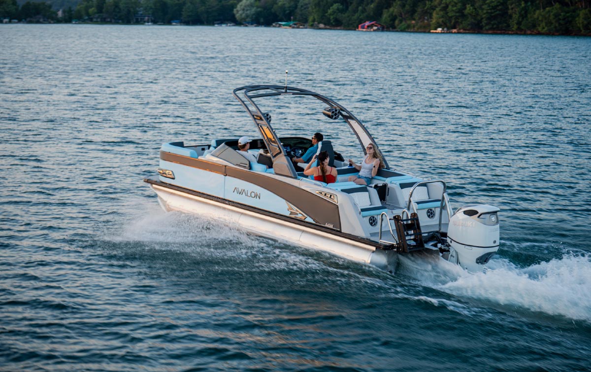 Avalon pontoon boat carrying passengers across open water on a sunny day.