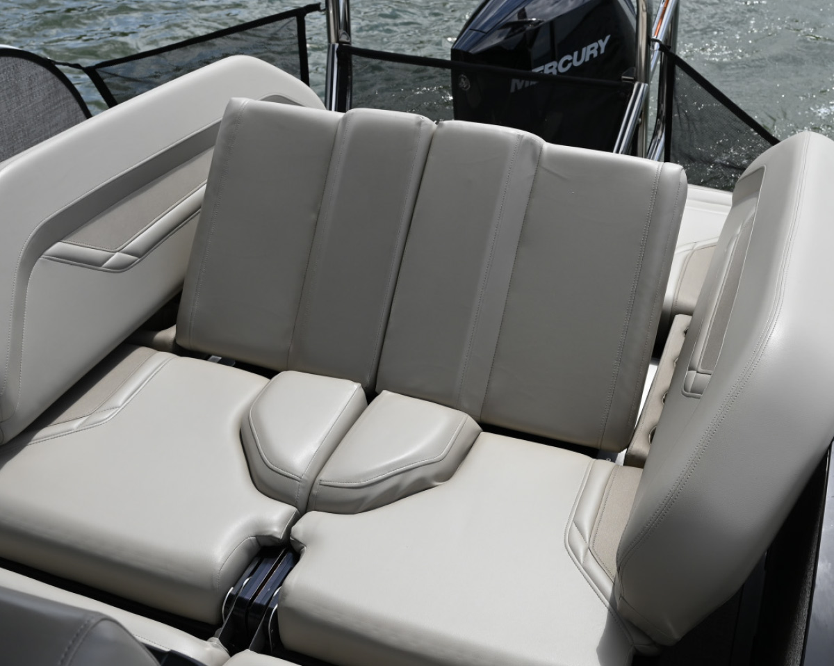 Reclining light grey vinyl stern seating inside a pontoon boat near the outboard motor.