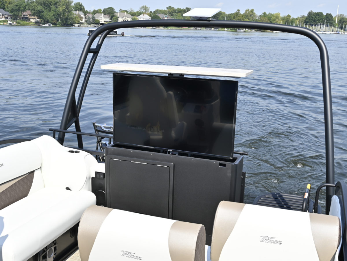 Flat-screen television mounted inside a pop-up console on the deck of a TriToon pontoon boat.