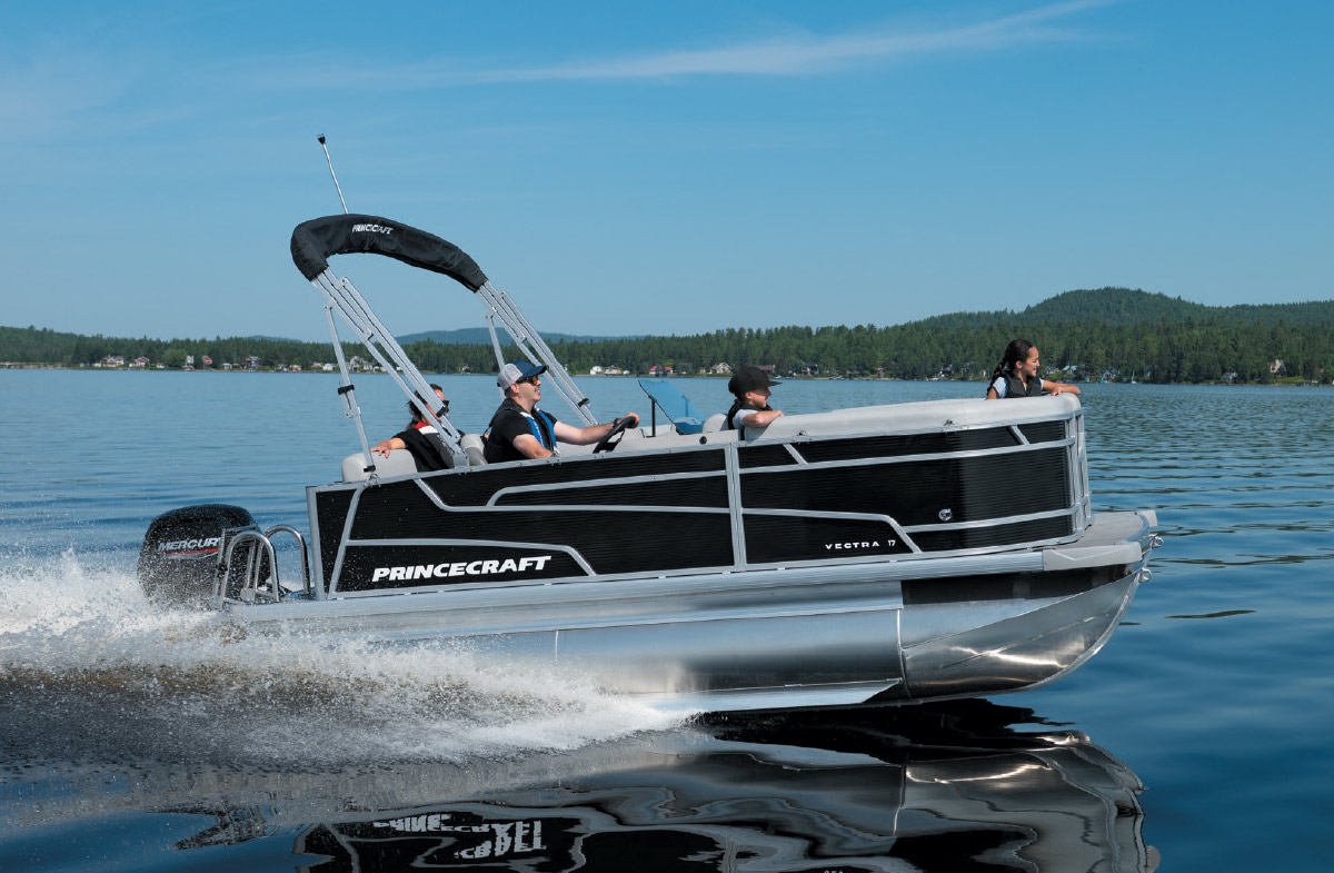 Princecraft Vectra 17 pontoon boat with four passengers cruising across a calm lake.