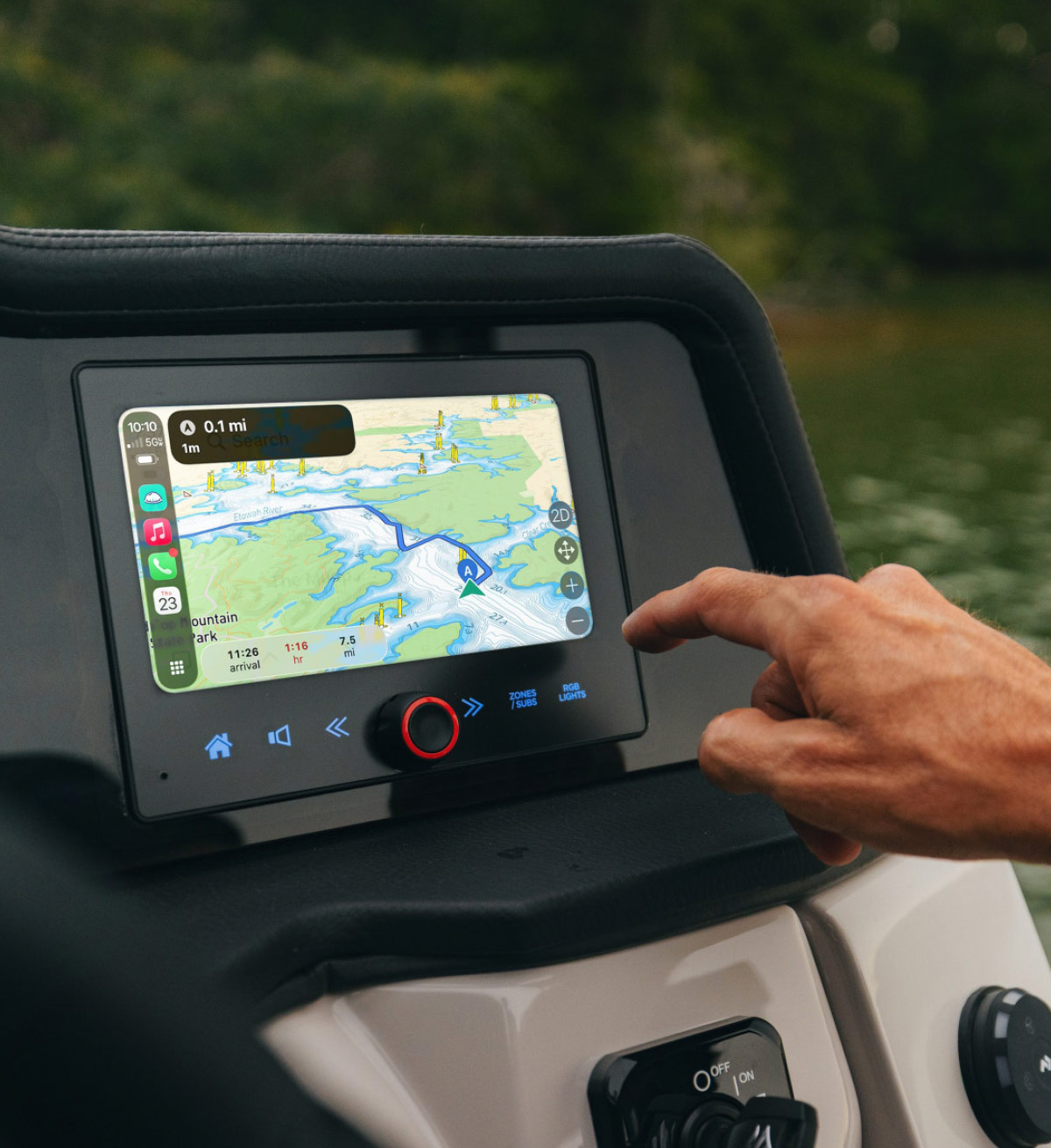 Close-up of a hand tapping a GPS navigation touchscreen display on a boat helm console.