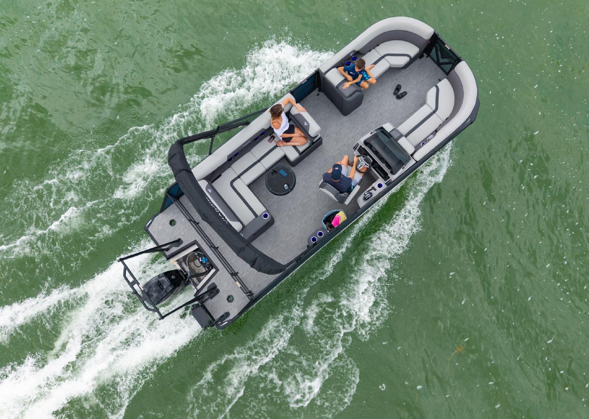 Directly overhead aerial view of a Viaggio pontoon boat with three passengers cruising through green water.